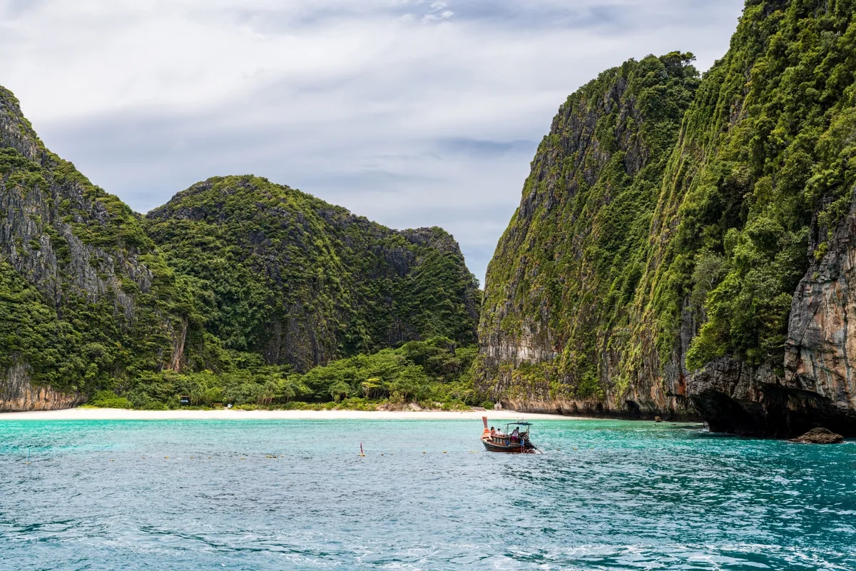 A longtail boat in the turquoise waters of Maya Bay, Phi Phi Islands near Phuket, Thailand